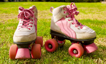 Beautiful pink roller skates on grass background
