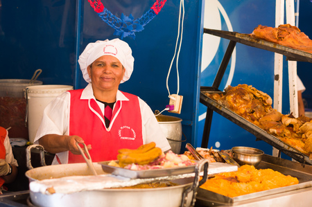 QUITO, ECUADOR- 07 MAY, 2017: Close up of an unidentified woman preparing hornado roasted pork ecuadorian traditional typical andean foodのeditorial素材