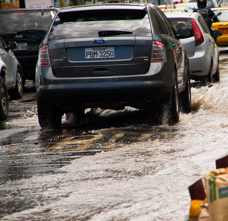 QUITO, ECUADOR - SEPTEMBER 20, 2016: Close up of expensive cars riding on a flooded road in Quito city after a heavy rainのeditorial素材