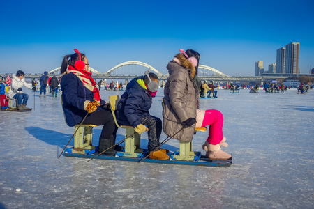 Harbin, China - February 9, 2017: Friends on a sled having fun on frozen river Songhua during winter time.のeditorial素材