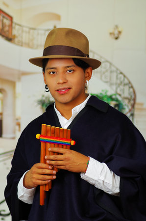Indigenous young man from Otavalo, Ecuador, playing the rondador