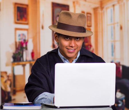 Close up portrait of indigenous young latin man using laptopの写真素材