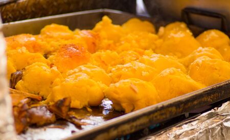 Woman wearing kitchen gloves and handling the mass of Smashed potato, to prepare a potato tortilla, ecuadorian traditional typical andean foodの写真素材