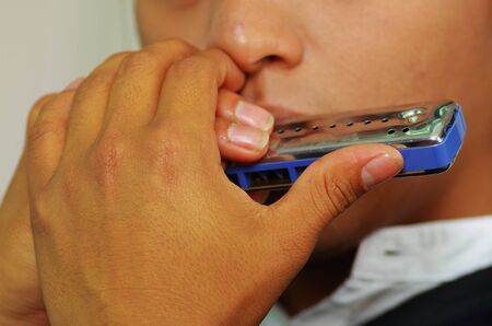 Indigenous young man playing the harmonicaの写真素材
