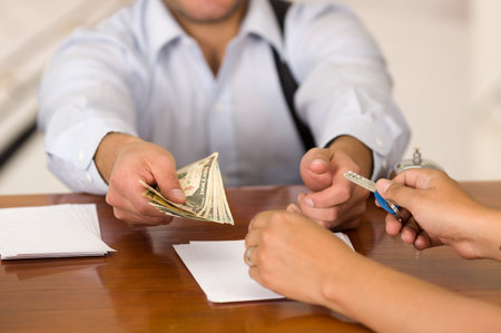 Guest pay the bill and receptionist in hotel giving key to guest