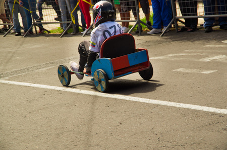 Quito, Ecuador - May 06, 2017: An unidentified boy racing a wooden car in the streets of city of Quito, back viewのeditorial素材