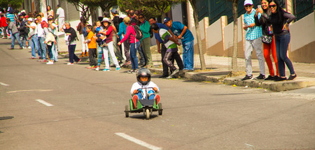 Quito, Ecuador - May 06, 2017: An unidentified boy racing a wooden car in the streets of city of Quitoのeditorial素材