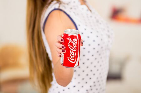 Quito, Ecuador - May 06, 2017: Young woman pointing in from of her a coke wearing a white with black points blouseのeditorial素材