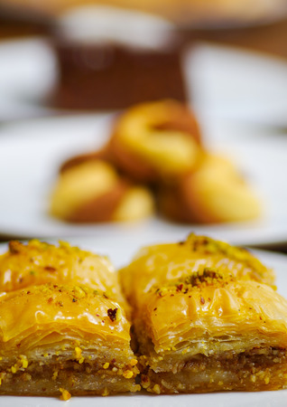 Close up of a delicious traditional turkish food baklava with pistachio on a white plate in blurred backgroundの写真素材
