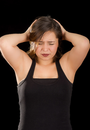 Female worker has pain in her head, in a black backgroundの写真素材