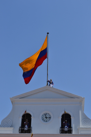 QUITO, ECUADOR - JANUARY 28, 2016: An unidentified guard during the change of turn on top of the Presidential Palace in the heart of Quito, with a colorful Ecuadorian flagのeditorial素材