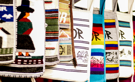 OTAVALO, ECUADOR - MAY 17, 2017: Beautiful andean traditional purse clothing textile yarn and woven by hand in wool, colorful fabrics backgroundのeditorial素材
