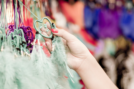 OTAVALO, ECUADOR - MAY 17, 2017: Close up of a woman holding a catchdreamer in her hand, in colorful market backgroundのeditorial素材