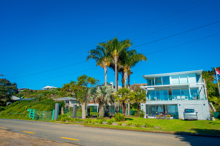AUCKLAND, NEW ZEALAND- MAY 12, 2017: Unidentified people sitting in the hall of his house with a beautiful view to the beach in a Waiheke Island, New Zealand with a beautiful blue sky in a sunny dayのeditorial素材