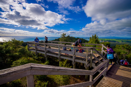 AUCKLAND, NEW ZEALAND- MAY 12, 2017: Unidentified people enjoying the beautiful view from top in the mountain in Rangitoto Island walking in wooden paths, New Zealand in a sunny dayのeditorial素材