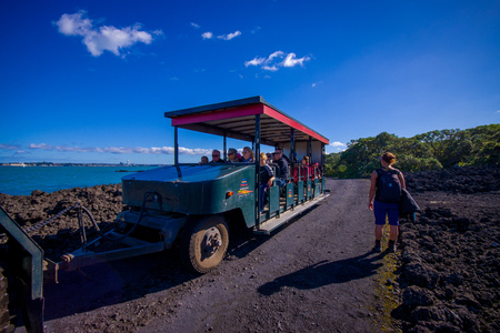 AUCKLAND, NEW ZEALAND- MAY 12, 2017: Unidentified people on a trip on a truck in a rocky road inside of the volcanic Rangitoto island, in a sunny dayのeditorial素材