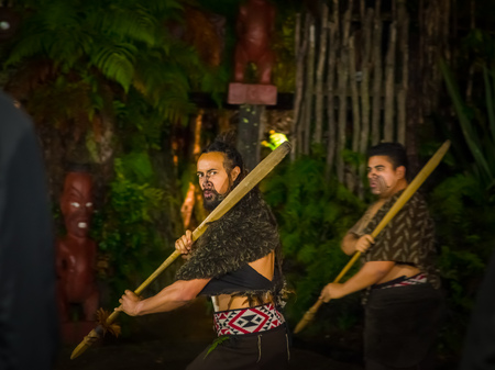 NORTH ISLAND, NEW ZEALAND- MAY 17, 2017: Maori men with traditionally tatooed face in traditional dress at Maori Culture doing a traditional dance, Tamaki Cultural Village, Rotorua, New Zealandのeditorial素材