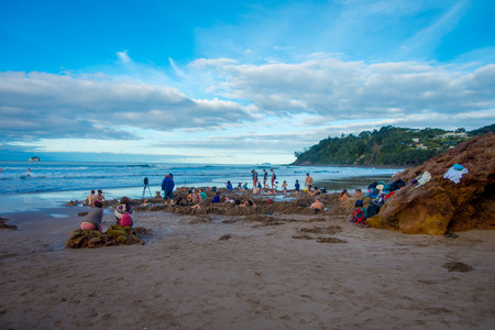 NORTH ISLAND, NEW ZEALAND- MAY 16, 2017: Tourists digging their own hot springs in Hot Water Beach, Coromandel. 130,000 annual visitors make it one of most popular attractions in Waikato region, in New Zealandのeditorial素材