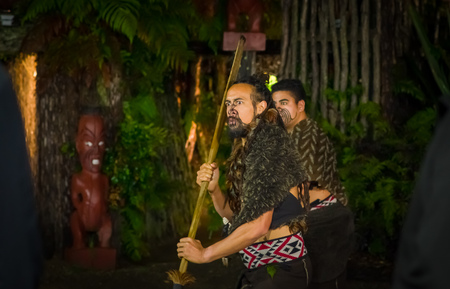 NORTH ISLAND, NEW ZEALAND- MAY 17, 2017: Maori men with traditionally tatooed face in traditional dress at Maori Culture doing a traditional dance, Tamaki Cultural Village, Rotorua, New Zealandのeditorial素材