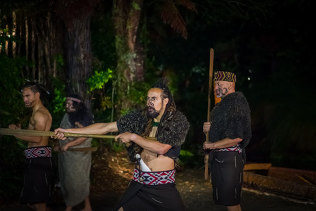NORTH ISLAND, NEW ZEALAND- MAY 17, 2017: Maori men with traditionally tatooed face in traditional dress at Maori Culture doing a traditional dance, Tamaki Cultural Village, Rotorua, New Zealandのeditorial素材