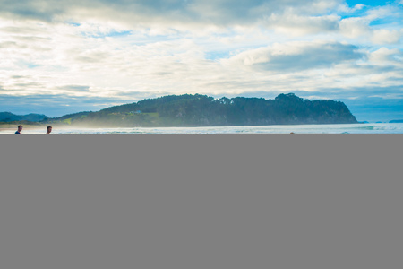 NORTH ISLAND, NEW ZEALAND- MAY 16, 2017: Tourists digging their own hot springs in Hot Water Beach, Coromandel. 130,000 annual visitors make it one of most popular attractions in Waikato region, in New Zealandのeditorial素材