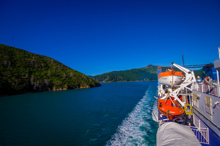 SOUTH ISLAND, NEW ZEALAND- MAY 25, 2017: Unidentified people enjoying the beautiful view from South island to North island at ferry, some orange boats on one side of the ferry, in New Zealandのeditorial素材
