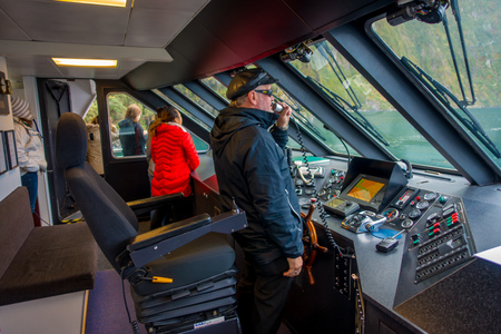SOUTH ISLAND, NEW ZEALAND- MAY 25, 2017: Close up of a ferry boat pilot command cabin with a smiling captain holding a cup of coffe with thumps up, in new zealandのeditorial素材