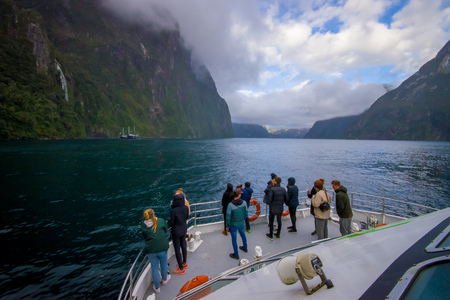 Unidentified crown of people enoying the beautiful landscape of high mountain glacier at milford sound with a beautiful lake, in south island in New Zealandの写真素材