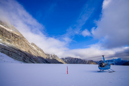 SOUTH ISLAND, NEW ZEALAND- MAY 24, 2017: Helicopter and pilot waiting over the snow for hunters in South Westlands Southern Alps, New Zealandのeditorial素材