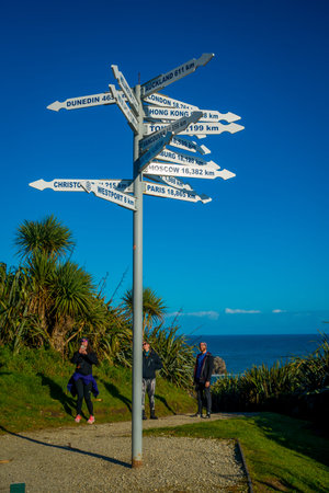 SOUTH ISLAND, NEW ZEALAND- MAY 23, 2017: Unidentified people looking at signpost at Cape Foulwind on the west coast of the South Island of New Zealandのeditorial素材