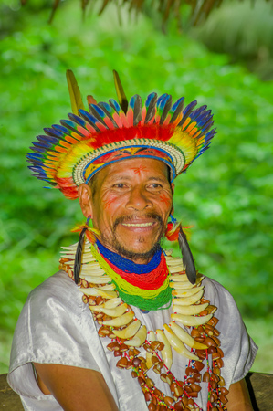 LAGO AGRIO, ECUADOR - NOVEMBER 17, 2016: Close up of a smiling Siona shaman in traditional dress with a feather hat in an indigenous village in the Cuyabeno Wildlife Reserveのeditorial素材