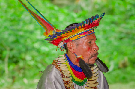 LAGO AGRIO, ECUADOR - NOVEMBER 17, 2016: Close up of a Siona shaman in traditional dress with a feather hat in an indigenous village in the Cuyabeno Wildlife Reserveのeditorial素材