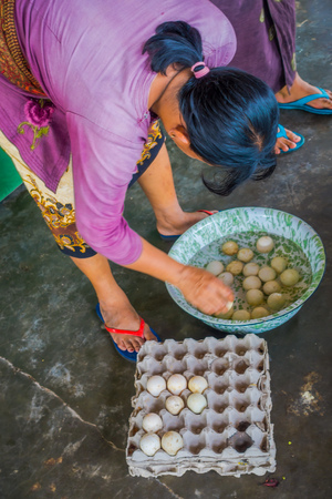 BALI, INDONESIA - MARCH 08, 2017: Women preparing an Indian Sadhu dough for chapati on Manmandir ghat using a turtle eggs, on the banks of the holy river Ganges in Varanasiのeditorial素材