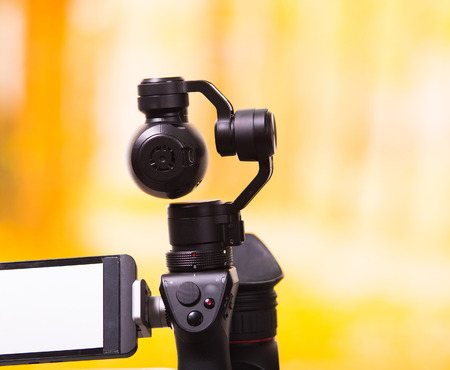 QUITO, ECUADOR- DECEMBER 22, 2017: Osmo Mobile gimbal, new generation of electronic stabilizer in a blurred forest backgroundのeditorial素材