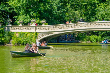 NEW YORK, USA - NOVEMBER 22, 2016: Unidentified people enjoying and paddling in Central Park in bow bridge, New York attracts 50 million tourists worldwide annually.のeditorial素材