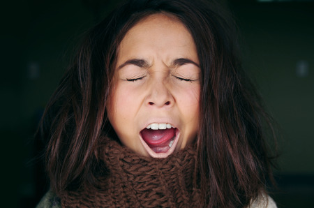 Closeup portrait headshot sleepy young woman with wide open mouth yawning eyes closed looking bored, in black backgroundの写真素材