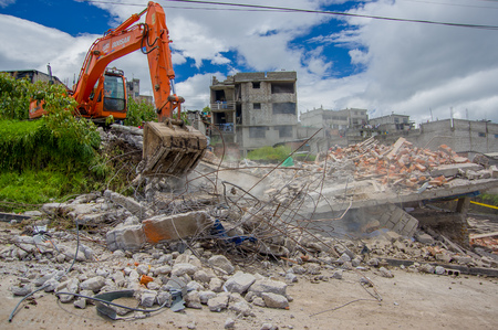 Quito, Ecuador - April,17, 2016: House destroyed by Earthquake, and heavy machinery cleaning the disaster in the city of Quito, Ecuador.のeditorial素材