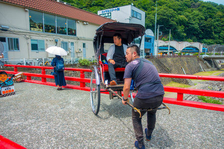 HAKONE, JAPAN - JULY 02, 2017: Unidentifies people over a red bridge at the river at Odawara,...