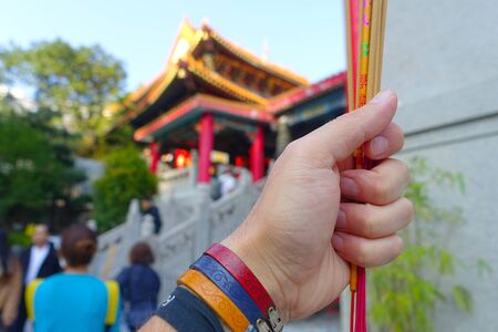 HONG KONG, CHINA - JANUARY 22, 2017: Close up of a hand holding an incense ticks at Wong Tai Sin Temple, Hong Kong, China.のeditorial素材