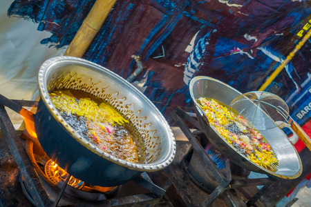 BALI, INDONESIA - MARCH 08, 2017: Cooking on a frying pan a dough for chapati on Manmandir ghat on the banks of the holy river Ganges in Varanasi on blue backgroundのeditorial素材