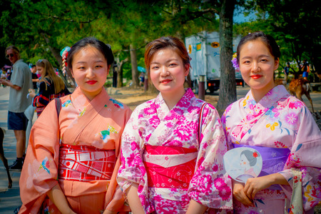 Nara, Japan - July 26, 2017: Unidentified women posing for camera in Nara park, Japan. Nara is a major tourism destination in Japanのeditorial素材