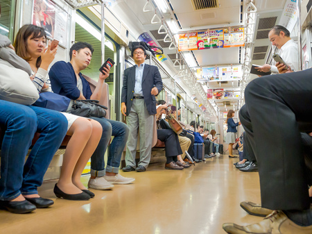 Tokyo, Japan - Jan 2, 2016. People sitting in a Yamanote train in Tokyo, Japan. The railway system in Japan has a high reputation for punctuality and safetyのeditorial素材