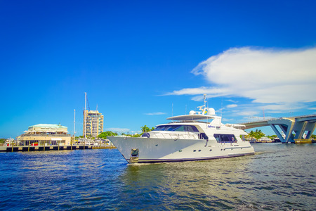 FORT LAUDERDALE, USA - JULY 11, 2017: Beautiful white yatch with a nice view behind of an opened draw bridge raised to let ship pass through at harbor in Fort Lauderdale, Floridaのeditorial素材