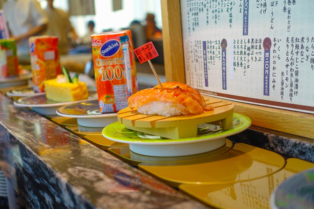 TOKYO, JAPAN -28 JUN 2017: Close up of assorted japanesse food over a table, inside of a kaitenzushi conveyor belt sushi restaurant in Tokyoのeditorial素材