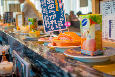 TOKYO, JAPAN -28 JUN 2017: Close up of assorted japanesse food over a table, inside of a kaitenzushi conveyor belt sushi restaurant in Tokyoのeditorial素材
