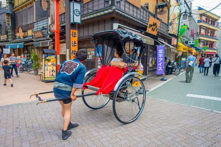 TOKYO, JAPAN JUNE 28 - 2017: Tourists rides a rickshaw at Sensoji Asakusa Kannon Temple in Tokyo, Japan. Rickshaws are a tourist attraction in the Asakusa region of Tokyoのeditorial素材