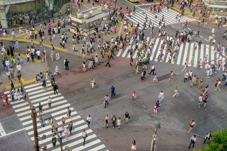 TOKYO, JAPAN JUNE 28 - 2017: Top view of crowd of people crossing in Shibuya street, one of the...