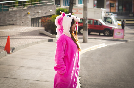Close up of a beautiful smiling young woman wearing an unicorn costume, at outdoors in the city of Quitoの写真素材