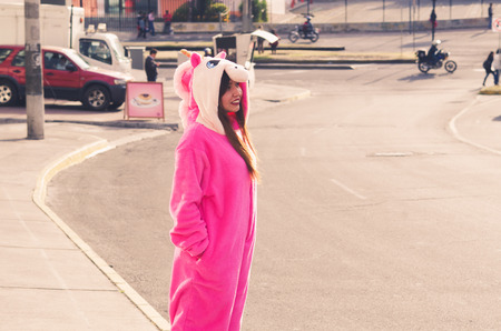 Close up of a beautiful smiling young woman wearing an unicorn costume, at outdoors in the city of Quitoの写真素材