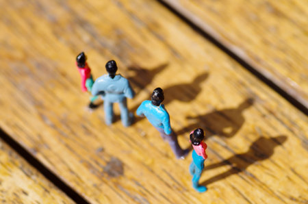 Miniature little people, friend at outdoors with shadow in the floor, in a wooden background